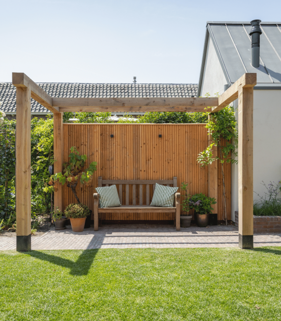 Houten pergola met rustgevend zitplekje in achtertuin